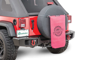 a red jeep with a pink sac hanging in the back