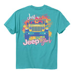 a teal shirt with an illustration of a yellow jeep surrounded by stylize images of tropical flowers with the words “just a jeep girl”