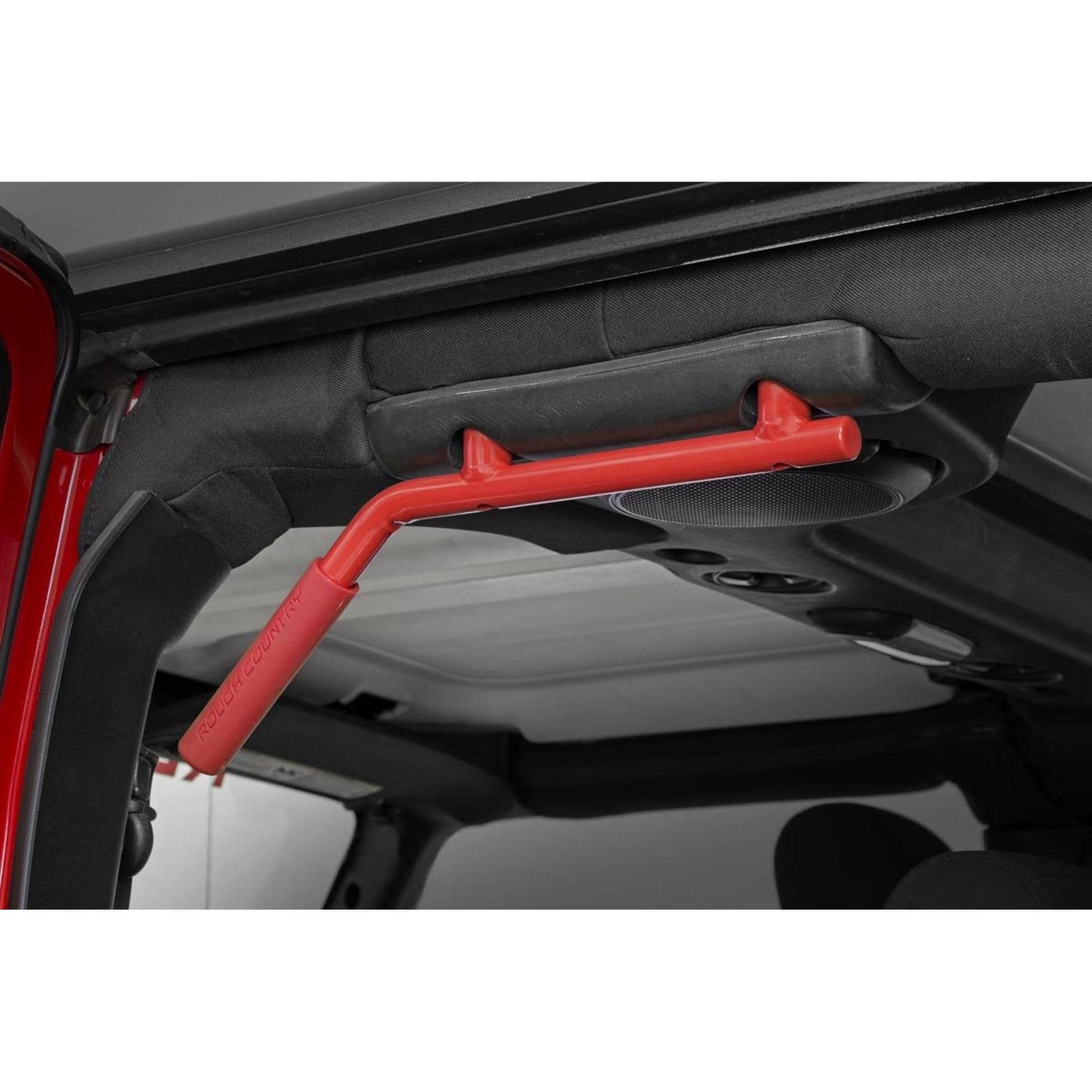 inside the open door of a jeep, a red metal grab bar is installed