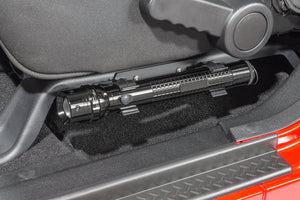 a cropped in photo of a vehicle’s driver seat with a silver metal flashlight mounted beneath