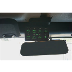 a control system with lit green buttons installed by a rearview mirror