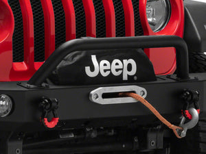 a red jeep with a visible winch line and jeep logo on winch cover