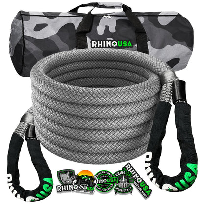 a gray coiled recovery rope sits in front of it’s packaging and carrying case