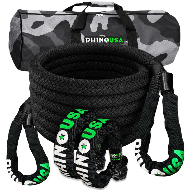 a black coiled recovery rope sits with 2 soft shackles in front of it’s carrying case