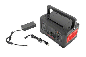 a black power station with a handle sat next to its charging cable